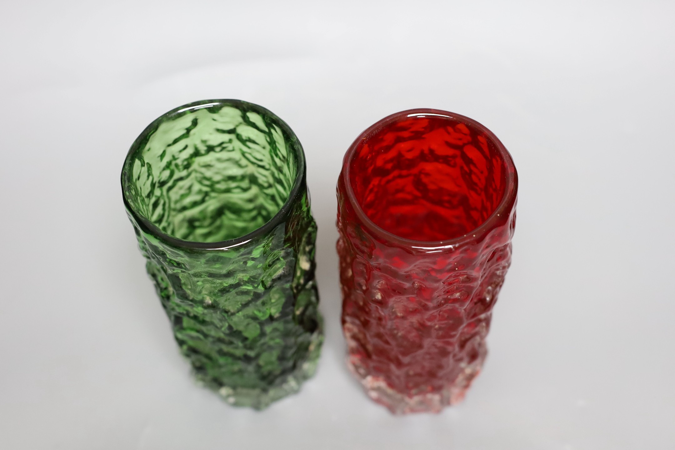 Two Whitefriars 'bark' cylinder vases, model 9689, designed by Geoffrey Baxter, in red and green glass, each 19cm high.